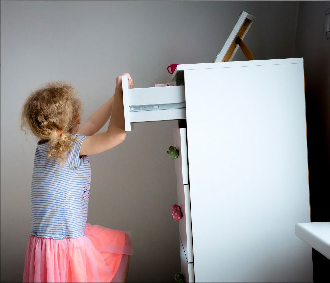 Child reaching for dresser